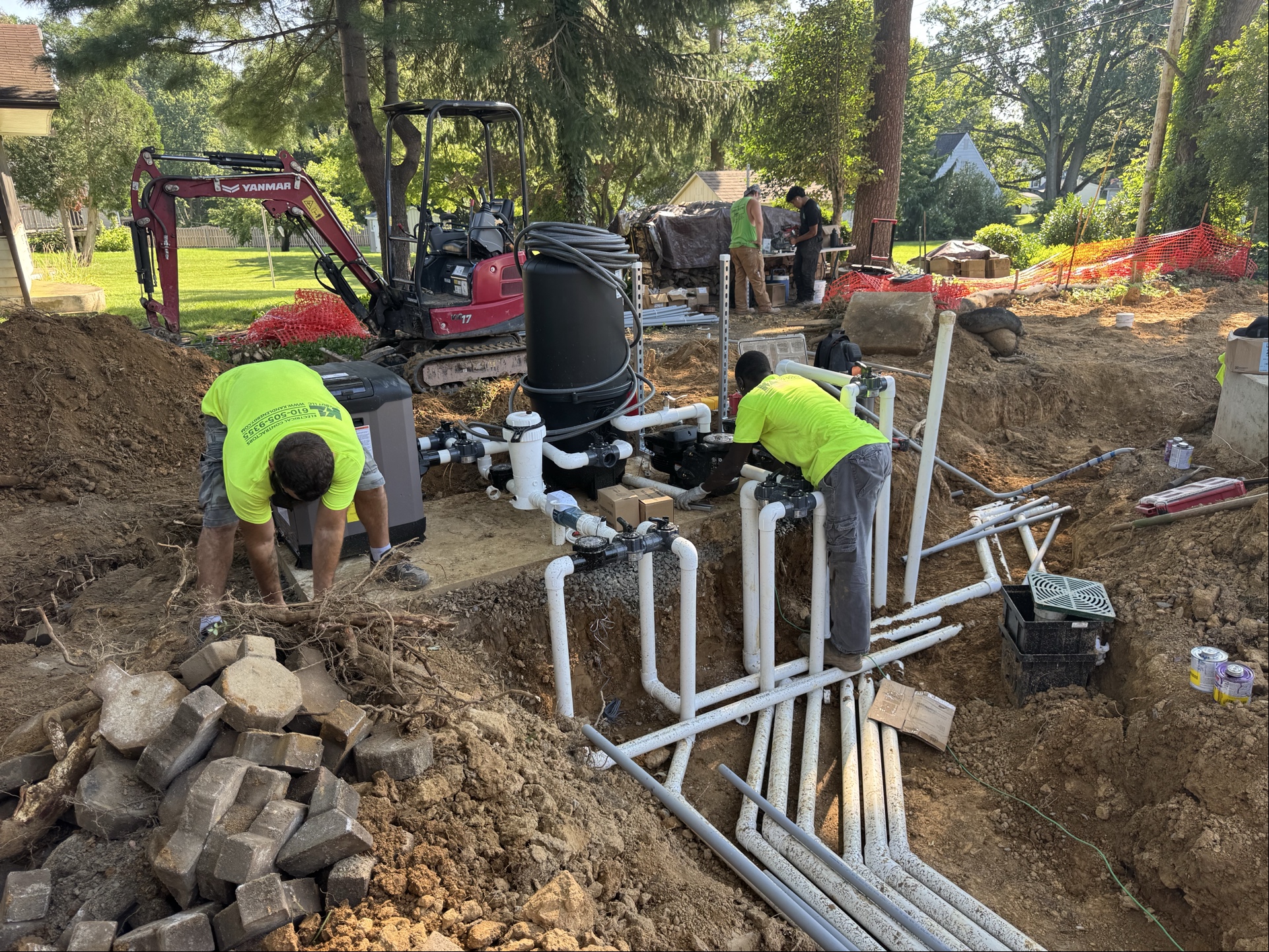 SPCP crew in green shirts installing pool equipment and plumbing